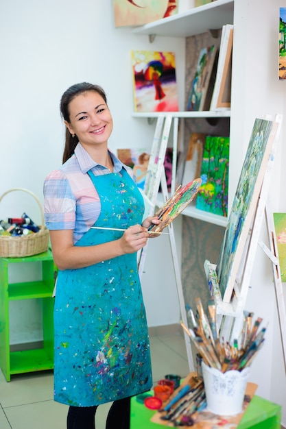 Linda garota desenha uma pintura de pinturas na aula de arte