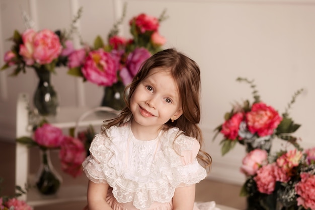 Linda garota doce em um vestido de renda rosa linda com flores