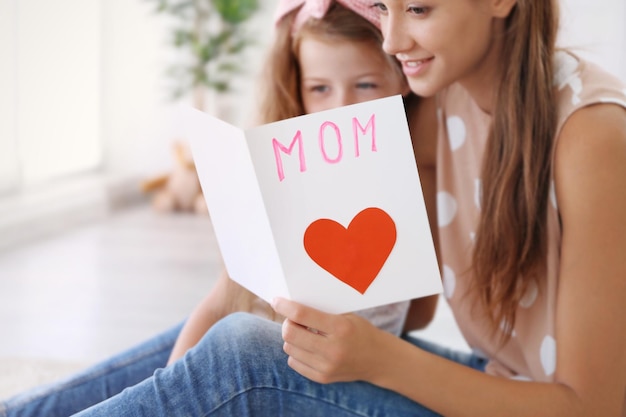 Foto linda garota e mãe com cartão artesanal conceito de dia das mães