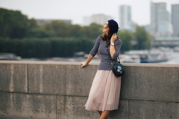 Linda garota elegante em Paris uma beleza em uma boina azul no fundo do Sena