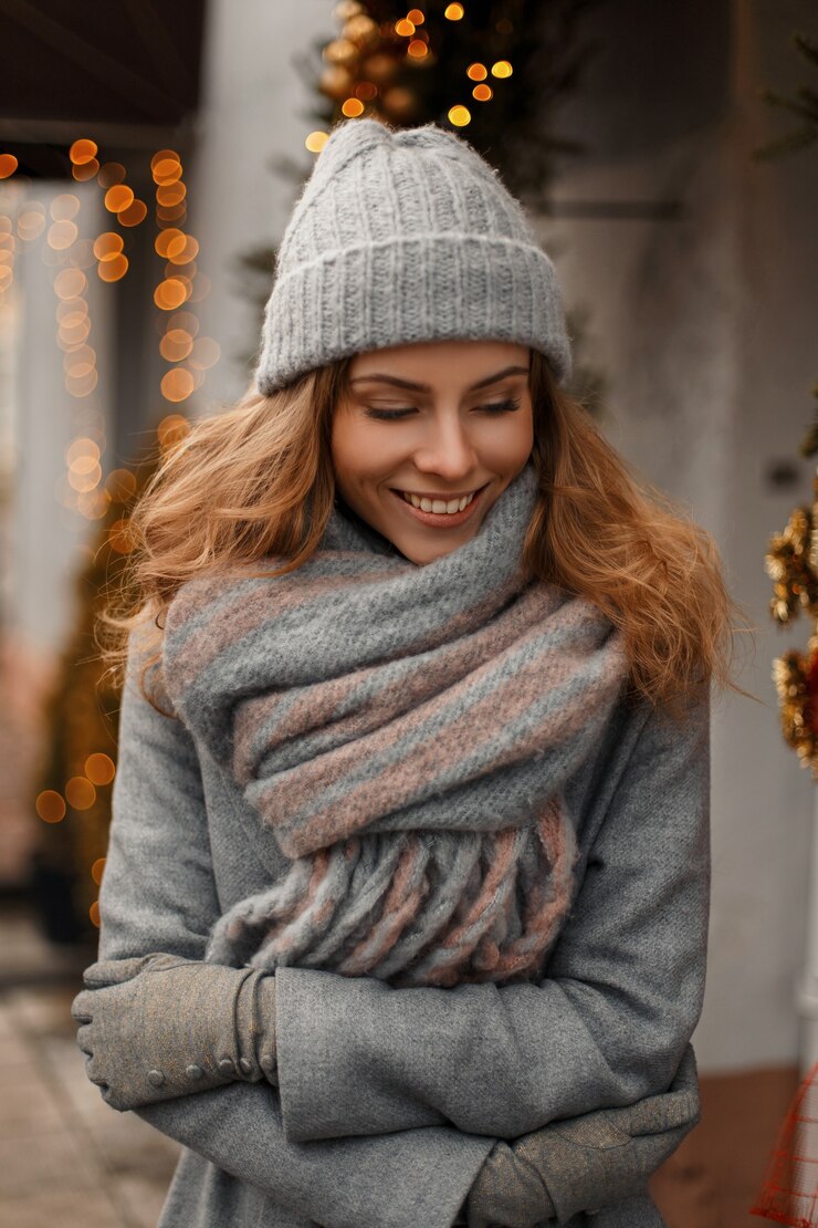 Foto linda garota elegante sorrindo na moda de inverno tricotando roupas cinza nas férias de inverno na rua perto das luzes