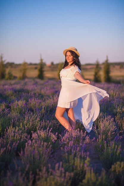 Linda garota em lavanda Ela está usando um vestido longo e um grande chapéu Espaço para texto