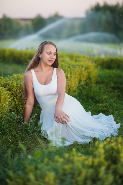 Linda garota em lavanda Ela está usando um vestido longo e um grande chapéu Lugar para texto A fonte