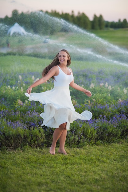 Linda garota em lavanda Ela está usando um vestido longo e um grande chapéu Lugar para texto A fonte