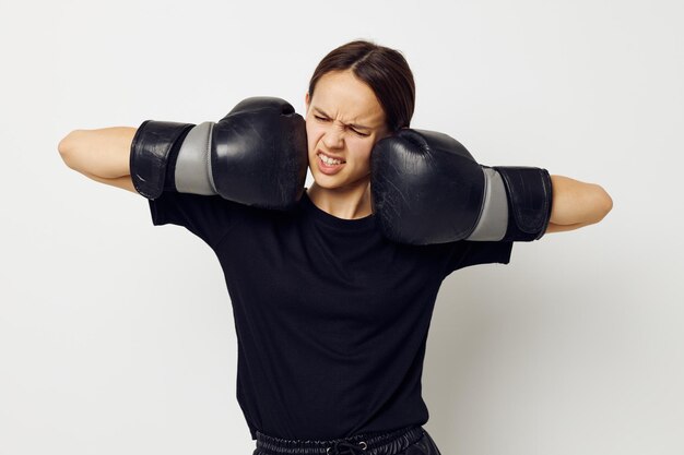 Linda garota em luvas de boxe em calças pretas e um estilo de vida de camiseta inalterado