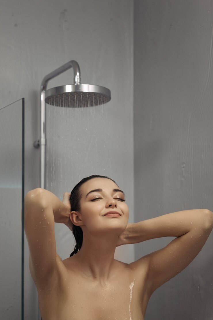 Foto linda garota em pé no chuveiro. retrato de mulher feliz mestiça caucasiana magro asiática