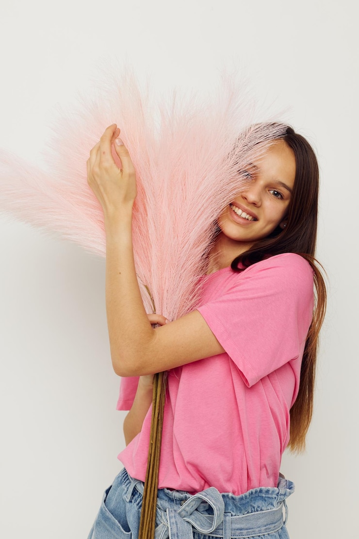 Foto linda garota em penas de camiseta rosa posando