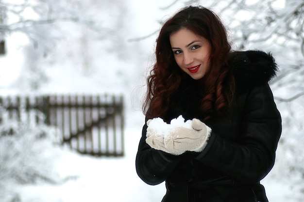 Linda garota em um dia de neve de inverno ao ar livre