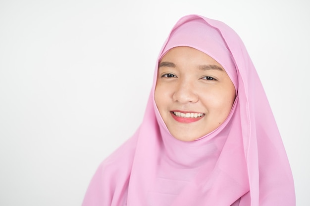 Linda garota em um hijab rosa em fundo branco