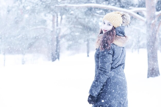 Linda garota em um lindo dia de parque de neve de inverno