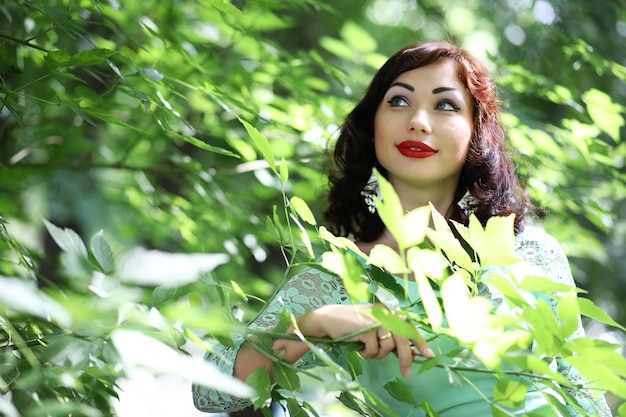 Linda garota em um parque de folhas de primavera à tarde