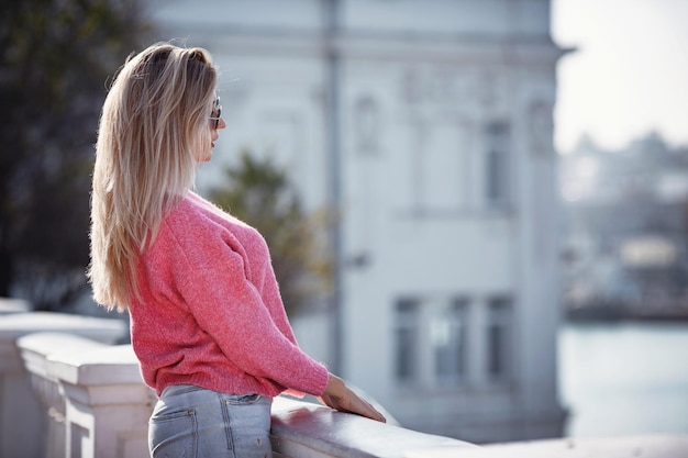 Linda garota em uma caminhada na cidade de outono mulher bonita em um suéter retrato de moda elegante mulher bonita ao ar livre jovem se divertindo na cidade moda de rua