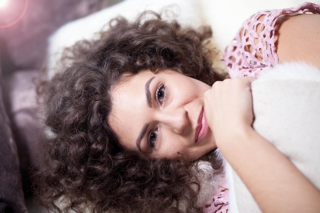 linda garota encaracolada na cama em um travesseiro o conceito de colchões e travesseiros ortopédicos