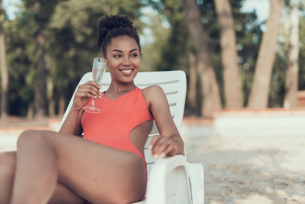 Foto linda garota está bebendo champanhe de vidro e sorrindo