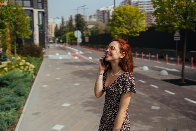 Linda garota falando no celular no fundo da cidade moderna