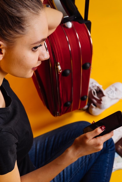 Foto linda garota faz uma viagem com uma grande mala vermelha adora viajar