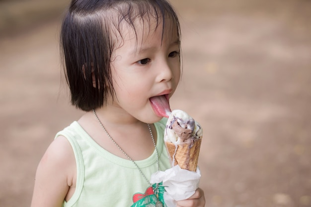 Linda garota gosta de comer um sorvete de chocolate derretendo