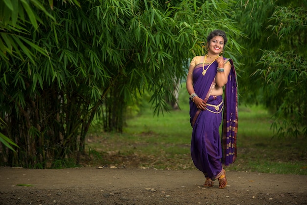 Linda garota indiana em Saree tradicional posando ao ar livre