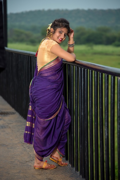 Linda garota indiana em Saree tradicional posando ao ar livre