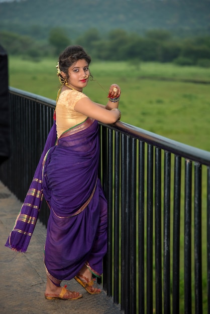 Linda garota indiana em Saree tradicional posando ao ar livre