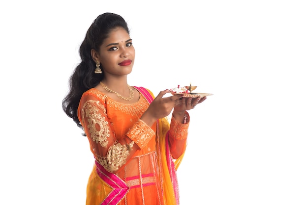 Linda garota indiana segurando pooja thali ou fazendo uma adoração em branco