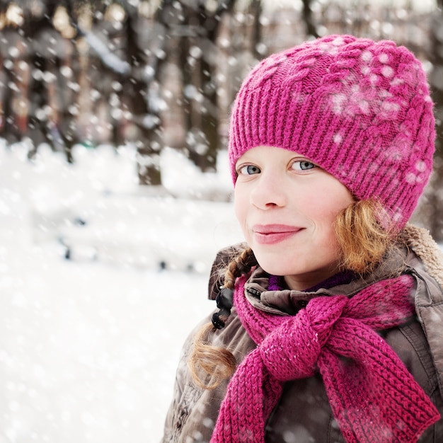 Linda garota jovem com neve em winter park ao ar livre