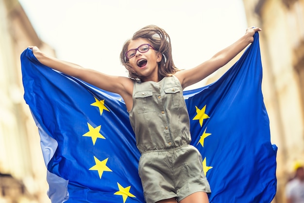 Linda garota jovem feliz com a bandeira da União Europeia.