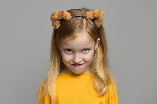 Foto linda garota loira com raiva com orelhas de tigre, um cocar com orelhas de tigre criança de ano novo em uma fantasia de tigre ...