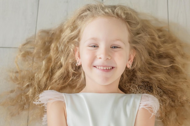 Linda garota loira feliz com cabelo encaracolado e olhos azuis sorriso