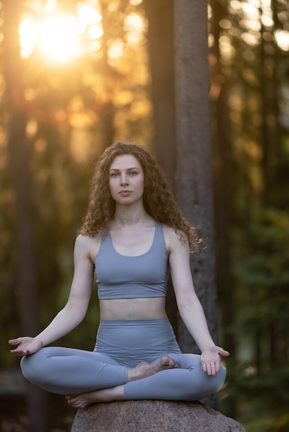 Linda garota meditando na prática de meditação de ioga na natureza