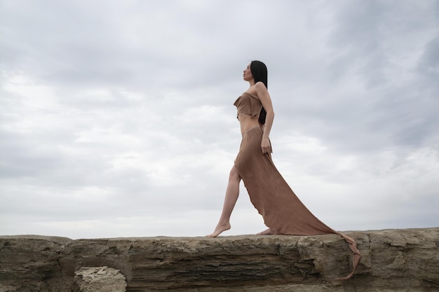 Linda garota morena em uma fantasia de amazona no deserto