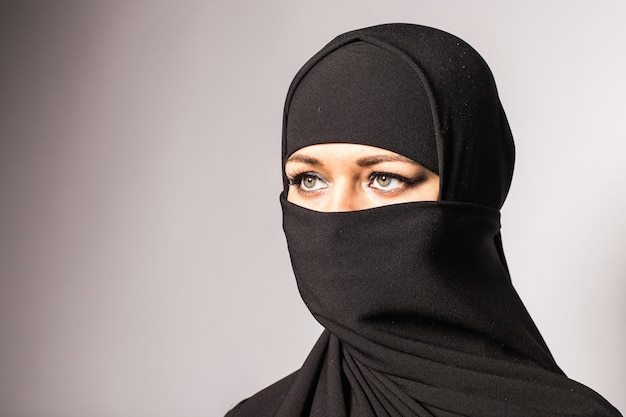 Linda garota muçulmana vestindo burca preta closeup.