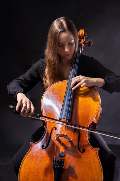 Linda garota músico tocando violoncelo