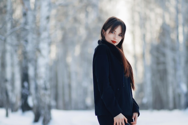 Linda garota na floresta de inverno rindo retrato de menina bonita no inverno com neve