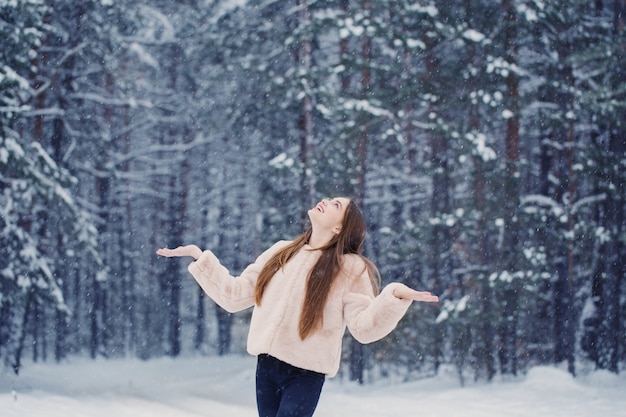 Linda garota na floresta de neve de inverno