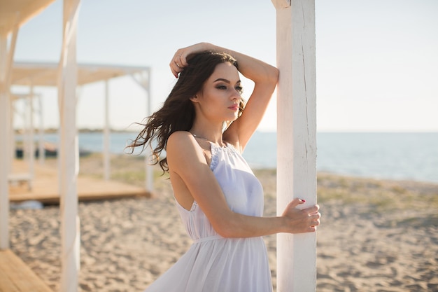 Linda garota na praia em um vestido branco.