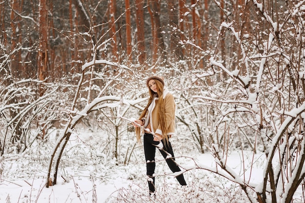 Linda garota no inverno no frio em uma caminhada na floresta