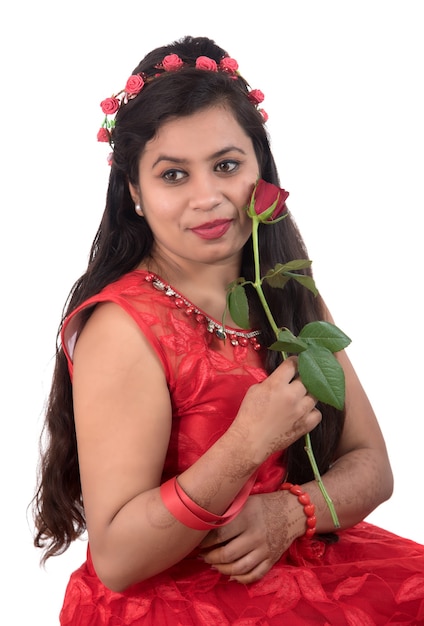 Linda garota ou mulher segurando e posando com uma flor rosa vermelha em branco