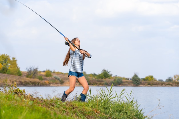 Linda garota peixes no lago.