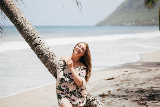 Linda garota perto da palmeira na praia