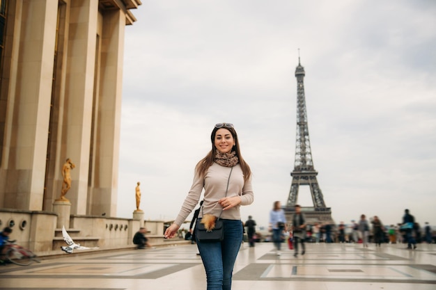 Linda garota posando para o fotógrafo no contexto do outono da torre eiffel