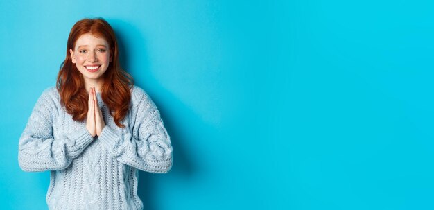 Linda garota ruiva dizendo obrigado sorrindo e olhando para a câmera expressando gratidão de pé novamente