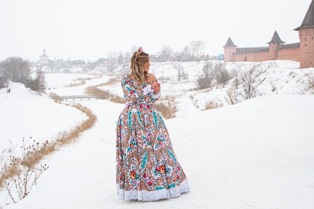 Linda garota russa em um vestido nacional de inverno