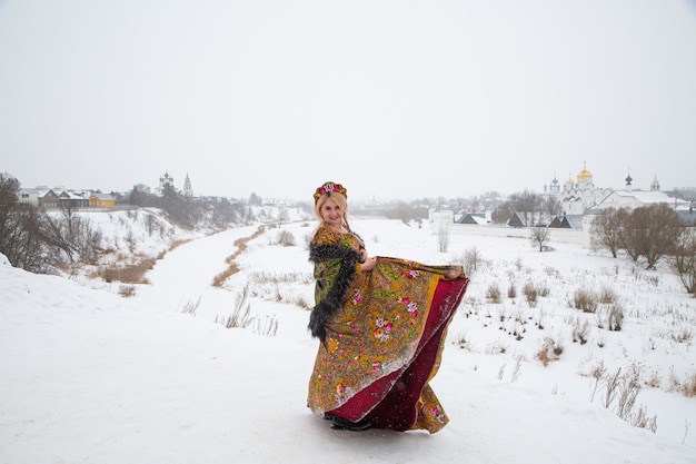 Linda garota russa em um vestido nacional de inverno