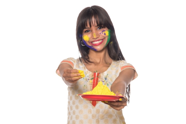 Linda garota segurando a cor em pó no prato por ocasião do festival de Holi.