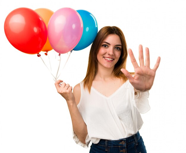 Linda garota segurando um balão e contando cinco