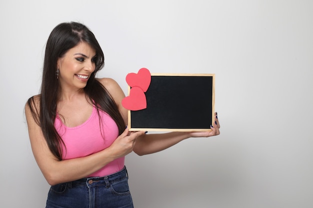 Linda garota segurando um presente do dia dos namorados no fundo branco