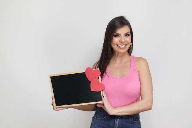 Linda garota segurando um presente do dia dos namorados no fundo branco