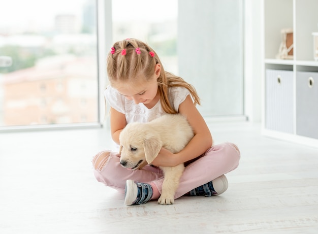 Linda garota sentada com filhote de cachorro adorável