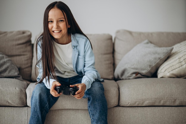 Linda garota sentada no treinador e jogando videogame no joypad